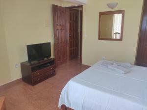 a bedroom with a bed and a flat screen tv at Apartamento acolhedor com vista para o Monte Cara in Mindelo