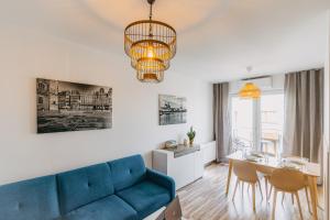 salon z niebieską kanapą i stołem w obiekcie Apartamenty City View od WroclawApartament-pl we Wrocławiu