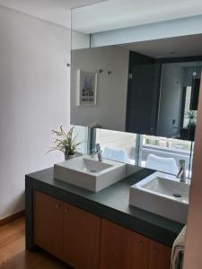 uma casa de banho com 2 lavatórios e um espelho grande em Villa Mar em Tróia
