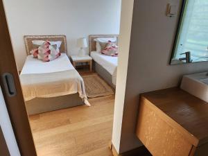 a small bedroom with two beds and a mirror at Villa Mar in Troia