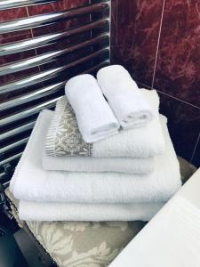 - une pile de serviettes sur une étagère dans une salle de bains dans l'établissement Hillcrest farmhouse Bed & Breakfast, à Boyhollagh