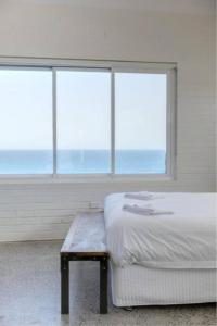 una camera con letto, tavolo e finestre di CLIFFSIDE: BONDI BEACH a Sydney