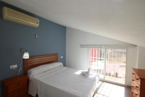 una camera da letto con un grande letto bianco e una finestra di Casa La Noria by Rental Olé a Murcia