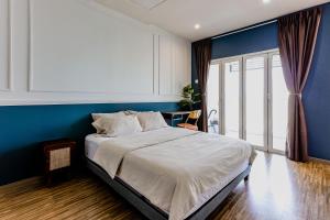 1 dormitorio con 1 cama grande y pared azul en SETAPAK CENTRAL KL-zeta suite by ALOHA en Kuala Lumpur
