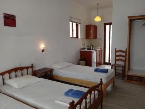 a room with two beds and a table and a kitchen at renesis studios in Lithakia