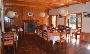 comedor con mesa, sillas y chimenea en Vivaan Stays -Holiday Home International, en Manali