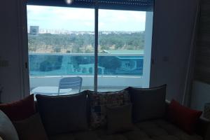 a living room with a couch and a large window at Cosy and Charming Apartment close to TUNISIA MALL Lac2 Tunis in Tunis