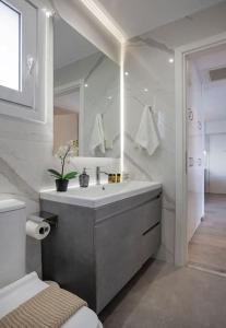 a white bathroom with a sink and a mirror at Sea view penthouse in Vari in Vari