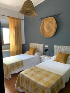 1 dormitorio con 2 camas y ventana en Molino El Mastral, en Tarifa