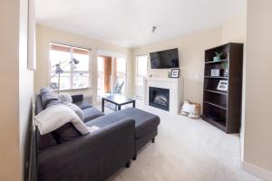 a living room with a couch and a fireplace at Downtown Osprey Condo at Waterscapes in Kelowna