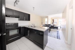 a kitchen with black cabinets and a counter top at Downtown Osprey Condo at Waterscapes in Kelowna