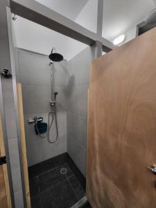 W łazience znajduje się prysznic ze szklanymi drzwiami. w obiekcie Central Hostel w Atenach