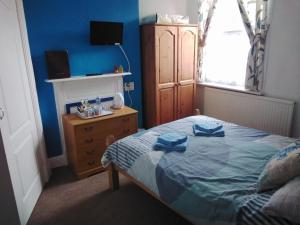 Un dormitorio con una cama con toallas azules. en Merriedale Guest House en Paignton