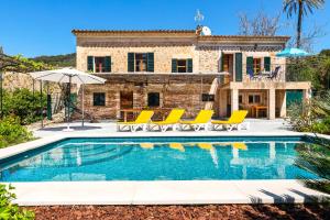 a villa with a swimming pool in front of a house at Villa Florida in Fornalutx