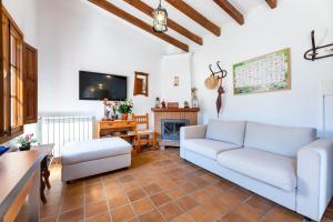 a living room with a couch and a tv at Villa Florida in Fornalutx