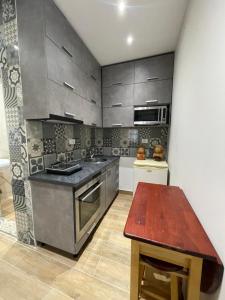 cocina con electrodomésticos de acero inoxidable y mesa de madera en Modern 1 Bedroom City Apartment, en Tirana