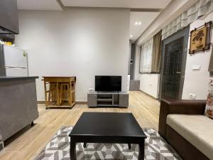 Una sala de estar con un sofá y un televisor. en Modern 1 Bedroom City Apartment, en Tirana