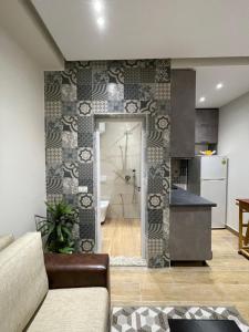 Una sala de estar con un sofá y una cocina. en Modern 1 Bedroom City Apartment, en Tirana