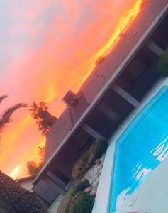 een uitzicht op een huis met een zwembad en een zonsondergang bij Luxury Home with private pool and full size basketball court in Las Vegas