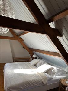 a bed in a room with a roof at Heerlijk Dijkhuisje in Paal in Graauw