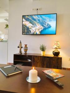 een kantoor met een tafel met een kaars en een tv aan de muur bij Casa Vikingo in San Fulgencio