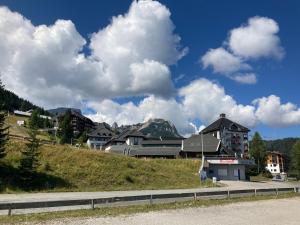 a group of houses on a hill next to a road at Appartment Silvia Nassfeld in Sonnenalpe Nassfeld