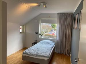 ein kleines Schlafzimmer mit einem Bett und einem Fenster in der Unterkunft Luxury Villa - Villa Seaside in Göteborg
