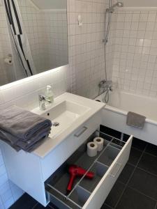 ein Badezimmer mit einem Waschbecken und einer Badewanne mit einem Spiegel in der Unterkunft Luxury Villa - Villa Seaside in Göteborg