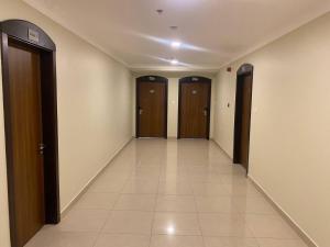 a hallway with three doors and a tile floor at HAVEN TOWER in Juffair