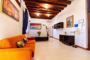 een woonkamer met een oranje bank en een tafel bij Art Dreams Apartment Dimora Casanova in Venetië