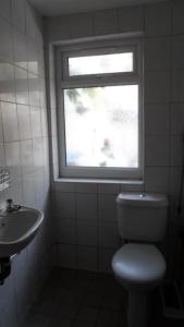 a bathroom with a window and a toilet and a sink at Bubblesbnb, 1 bedroom flat in London