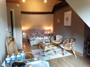 um quarto com uma cama, cadeiras e uma mesa em La Vallée Verte em Grandchamp