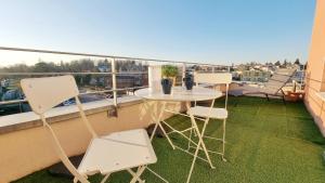 taras ze stołem i krzesłami na balkonie w obiekcie Le SMART - Parking - Terrasse - Wifi - Mulhouse - Relax BNB w mieście Pfastatt