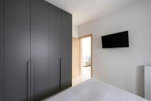 1 dormitorio con 1 cama y TV en la pared en Twin Superior Suites, en Tesalónica