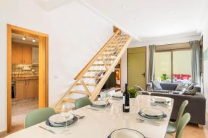 a dining room with a table and chairs and a staircase at MEDANO4YOU Los Patios Family and Sports Home in El Médano