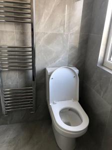 a bathroom with a white toilet and a window at Rahal Ilford in Ilford