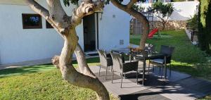 une table et des chaises sur une terrasse à côté d'un arbre dans l'établissement Excellent recently renovated villa in Torremuelle, à Torremuelle