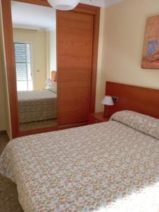 1 dormitorio con 2 camas y un espejo grande en Piso Rubarsal, en Torrox Costa