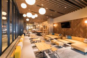 a restaurant with couches and tables and chairs at Tokyu Stay Takanawa Shinagawa Area in Tokyo