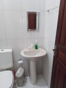 a white bathroom with a sink and a toilet at Centric Alter a 600m da praia in Alter do Chao