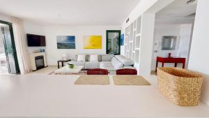 a white living room with a white couch and chairs at Villa Lili in L'Ampolla