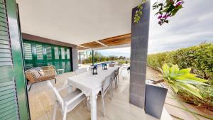 an outdoor patio with a white table and chairs at Villa Lili in L'Ampolla