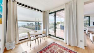 a dining room with a table and a large window at Villa Lili in L'Ampolla
