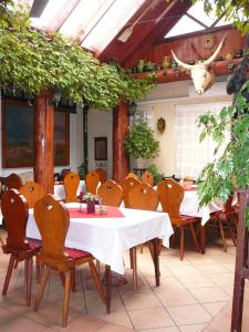un restaurante con mesa y sillas y una cabeza de vaca en la pared en Kemencés Csárda és Panzió, en Hajdúszoboszló