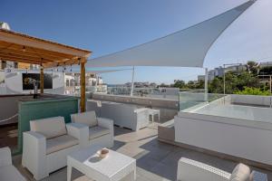 a balcony with white chairs and a bar on a building at Sun Lovers Hostel in Albufeira