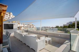 a balcony with white furniture and a view of the city at Sun Lovers Hostel in Albufeira