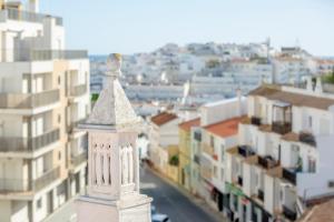 a white tower on top of a city with buildings at Sun Lovers Hostel in Albufeira