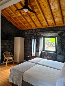 een slaapkamer met een bed en een plafondventilator bij Quinta do Caminho da Igreja TER-Casas de Campo in Velas