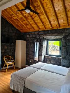 a bedroom with a bed and a ceiling fan at Quinta do Caminho da Igreja TER-Casas de Campo in Velas