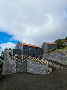 a castle with a stone wall and a bridge at Quinta do Caminho da Igreja TER-Casas de Campo in Velas